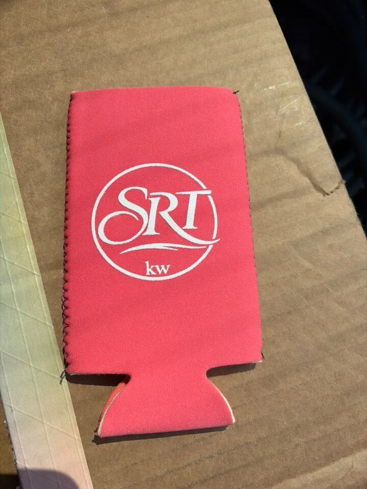 A red Sean Ryan Team koozie printed with the circular SRT Keller Williams logo.